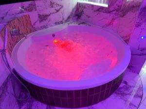 a bath tub filled with red liquid in a bathroom at Azura Suites in Bradford +12 photos