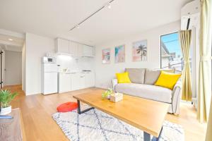 a living room with a couch and a table at 逗子海岸テラス 2階 in Zushi