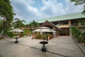 two umbrellas sitting in front of a building at Rayong Royal Residence in Ban Chang