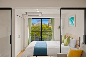 a bedroom with a bed and a large window at 逗子海岸テラス 2階 in Zushi