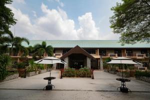 a building with two umbrellas in front of it at Rayong Royal Residence in Ban Chang