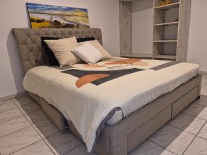 a bed in a room with a painting on the wall at Oya - Destination Guyane in Macouria