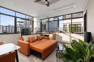 a living room with a couch and some windows at 3A Hometel Hanoi in Hanoi