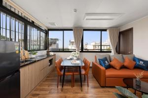 a kitchen and living room with a couch and a table at 3A Hometel Hanoi in Hanoi