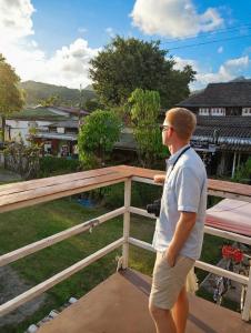 a man standing on top of a fence at Baan Pranai In Pai in Pai