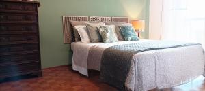 a bedroom with a bed with pillows and a dresser at QuickHome Appartamento Rovere in Biella