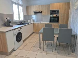 a kitchen with a table and a washing machine at Oya - Destination Guyane in Macouria