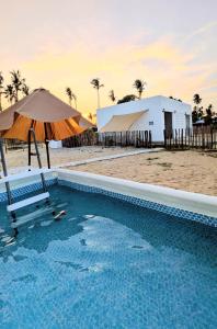 a pool with a chair and an umbrella and a building at Zulis Haven Stay in Kuala Rompin