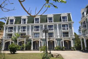 a large white building with a green roof at Evermist Resort DaLat in Da Lat