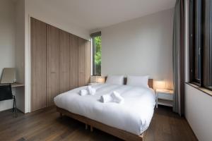a bedroom with a large white bed with two pillows at Song Saa Chalet in Niseko