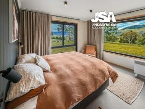 a bedroom with a large bed and a large window at The Orchard in Moonbah