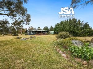 a house in the middle of a grassy field at The Orchard in Moonbah