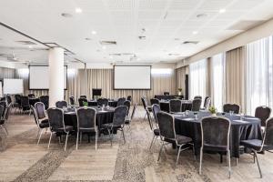 a conference room with tables and chairs and a projection screen at Metro Hotel Perth in Perth