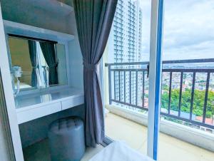 a room with a balcony with a large window at Lovina Spacious Double Studio at Formosa Nagoya in Jodoh