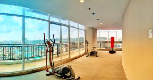 a gym with exercise bikes in a room with a large window at Lovina Spacious Double Studio at Formosa Nagoya in Jodoh