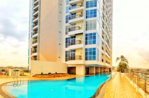 a hotel with a swimming pool in front of a building at Lovina Spacious Double Studio at Formosa Nagoya in Jodoh