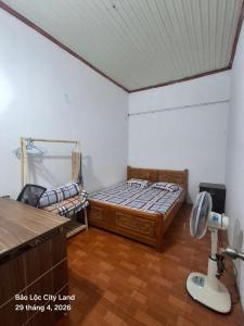 a bedroom with a bed and a desk in it at Lương Y Trần Thúy Liên in Bảo Lộc