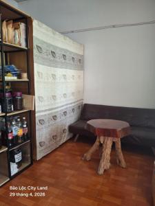 a living room with a couch and a stool at Lương Y Trần Thúy Liên in Bảo Lộc
