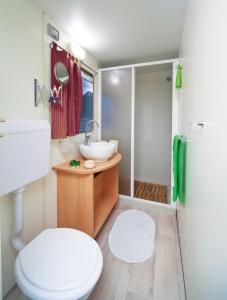 a bathroom with a toilet and a sink and a shower at Blu International Camping in Bolsena +27 photos