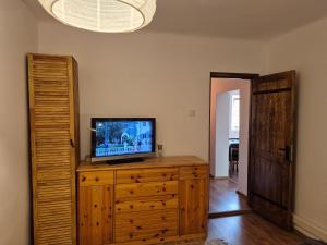 a living room with a tv on a wooden dresser at Casa LADIS in Iernut
