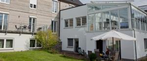 a person sitting under an umbrella in front of a house at Haus am Mühlberg in Modautal