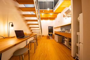 a loft kitchen with a desk with a laptop on it at いなぎの木箱 in Zentsuji