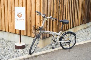a bike is parked next to a fence at いなぎの木箱 in Zentsuji