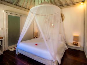 a bedroom with a white bed with a canopy at Ora Resort Gili Meno in Gili Meno +44 photos