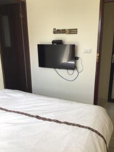 a bed with a television attached to a wall at 小魷魚輕旅 in Xiaoliuqiu +56 photos