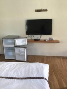 a bedroom with a tv on a wall and a bed at 小魷魚輕旅 in Xiaoliuqiu