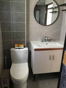 a bathroom with a white toilet and a sink at 小魷魚輕旅 in Xiaoliuqiu