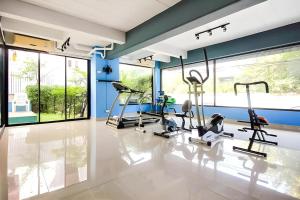 a gym with cardio equipment in a room with windows at Chill Guest in Ban Khlong Khwang Klang