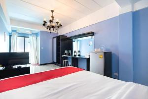 a blue room with a bed and a refrigerator at Chill Guest in Ban Khlong Khwang Klang