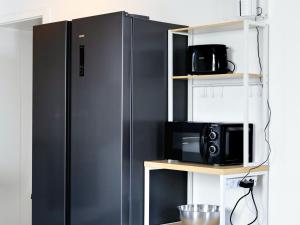a black refrigerator in a kitchen with a microwave at BudgetRoom 3 BR perfect for Teams in Castrop-Rauxel