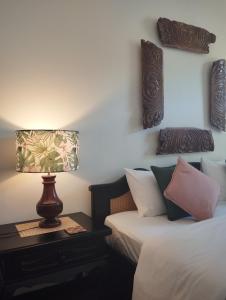 a bedroom with two beds and a lamp on a table at The Next Door in Kandy