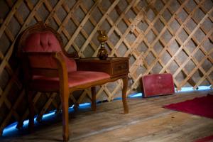 a red chair sitting next to a desk in a yurt at STF Nyrups Naturhotell in Höör
