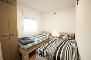 a bedroom with two beds and a window at Hill House Vrcelinija in Vuglovec