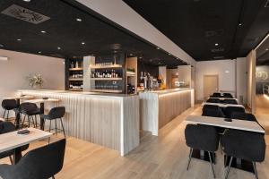 a restaurant with a bar with tables and chairs at Hotel Arrosadía Iriguibel in Pamplona