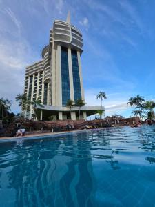 a hotel with a swimming pool in front of it at Suíte com varanda Tropical Hotel in Manaus