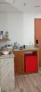 a kitchen with a sink and a red stool at Suíte com varanda Tropical Hotel in Manaus