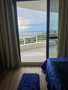 a bedroom with a view of the ocean from a balcony at Suíte com varanda Tropical Hotel in Manaus