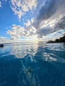 a pool of blue water with a cloudy sky at Suíte com varanda Tropical Hotel in Manaus
