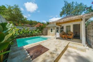 a backyard with a swimming pool and a house at Ora Resort Gili Meno in Gili Meno