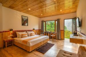 a bedroom with a large bed in a room with wooden ceilings at The Social Stays Tirthan in Bandal +63 photos