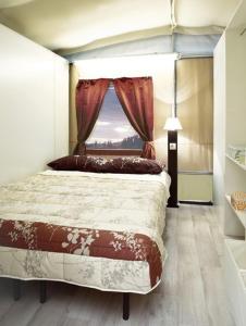 a bedroom with a large bed with a window at Blu International Camping in Bolsena