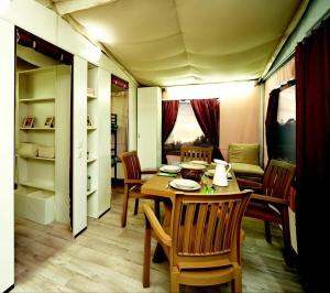 a dining room with a table and chairs in a room at Blu International Camping in Bolsena