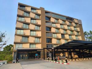 a large building with a parking lot in front of it at The 28th Hotel in Kanchanaburi City