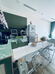 a kitchen with a white table and chairs in it at Canary Nest Solforest Ecopark Homestay in Kim Quan