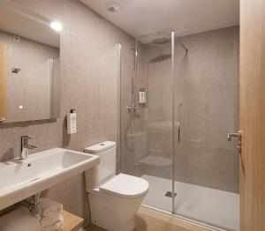 a bathroom with a shower and a toilet and a sink at Hotel Arrosadía Iriguibel in Pamplona +31 photos