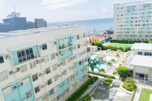 an apartment building with the ocean in the background at Bayview Haven Studio at Marina Spatial Condominium in Piapi